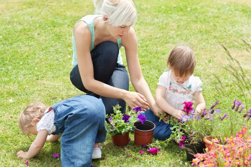 Garden maintenance crew using eco-friendly equipment on a canal-side garden